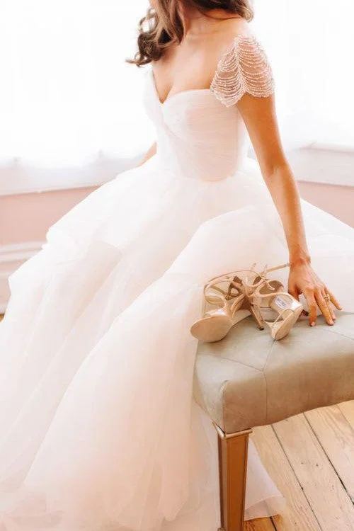 Cape - backed wedding dress for a dramatic entrancePearls Cap Sleeves Wedding Dresses with Irregular Tulle Skirt Cape - backed wedding dress for a dramatic entrancePearls Cap Sleeves Wedding Dresses with Irregular Tulle Skirt